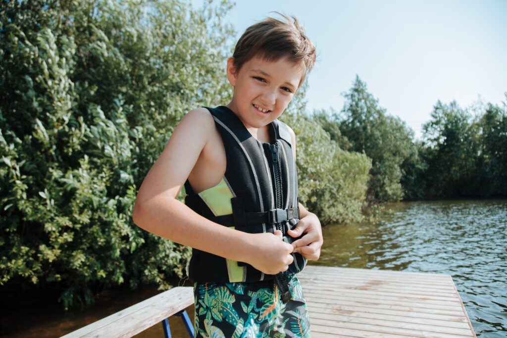 Portrait of Boy in Life Jacket on Lakeshore